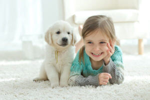 Girl and puppy relaxing on freshly cleaned rug