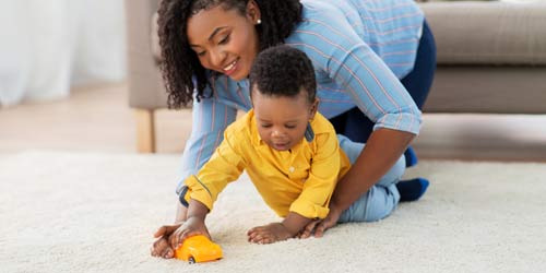 mother playing with son on safedry cleaned carpet