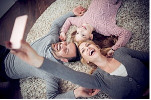 family taking group selfie on carpet after a professional carpet cleaning